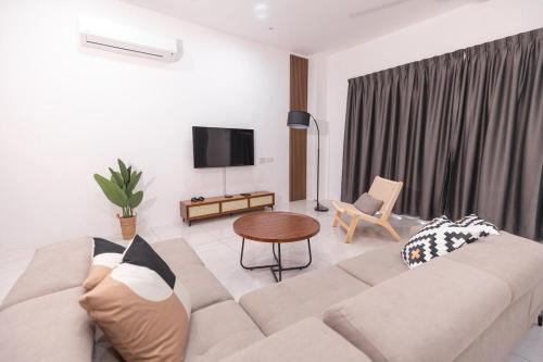 a living room with a couch and a tv at Taiping Bali Home 5R3B, 7mins-Tpg Lake Gardens in Taiping