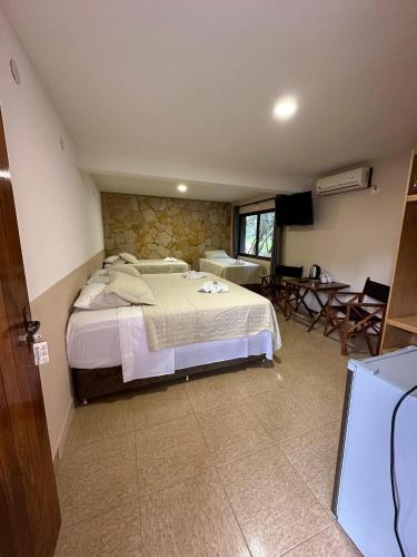 a bedroom with a large bed and a living room at Parque Hotel Manantial in Hohenau
