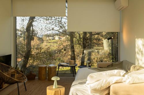 a bedroom with a bed and a large window at Bisas Villa in Caminha
