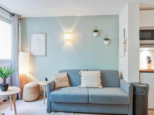 un salon avec un canapé bleu et une table dans l'établissement Charmant Duplex Montpellier - City Center, à Montpellier