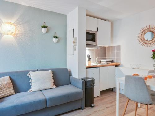 un salon avec un canapé bleu et une cuisine dans l'établissement Charmant Duplex Montpellier - City Center, à Montpellier