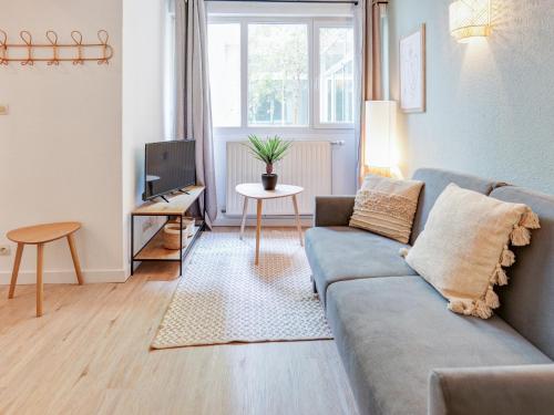 un salon avec un canapé et une télévision dans l'établissement Charmant Duplex Montpellier - City Center, à Montpellier