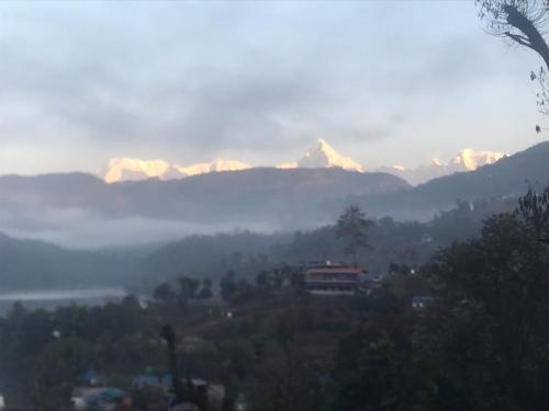 a view of a mountain range with mountains in the background at Little Heaven Restaurant &guest House in Deorāli