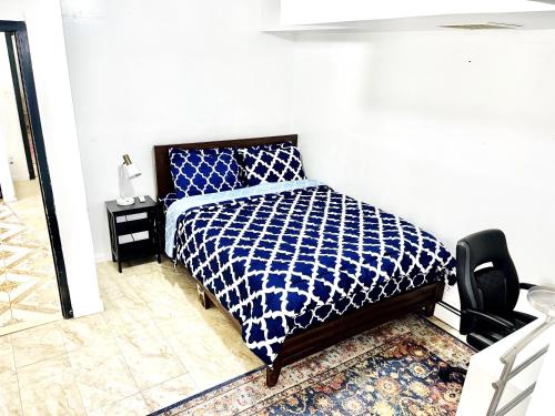Roosevelt IslandPRIVATE 2 BR Apt with PRIVATE Backyard in LIC !!!的卧室里有一张床，床铺有蓝白相间的被子