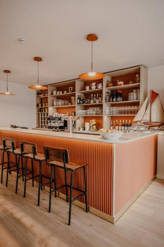 a bar with four chairs and an orange stripe at Dek in Landunvez