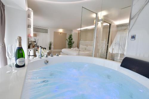 a large tub with a bottle of wine in a bathroom at Domus De Cinti in Tivoli