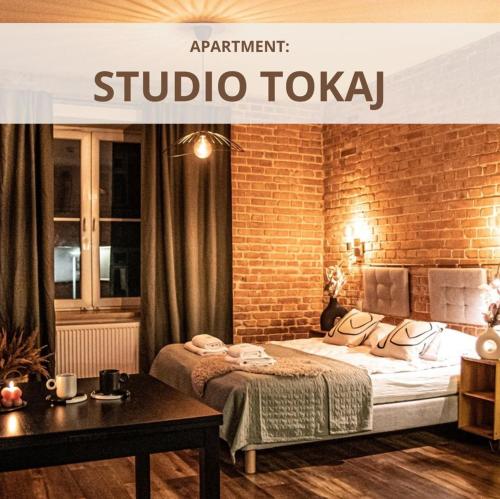 a hotel room with a bed and a brick wall at Wine Apartments in Kraków