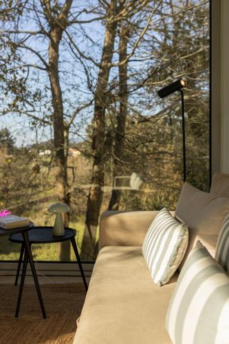 a living room with a couch and a large window at Bisas Villa in Caminha