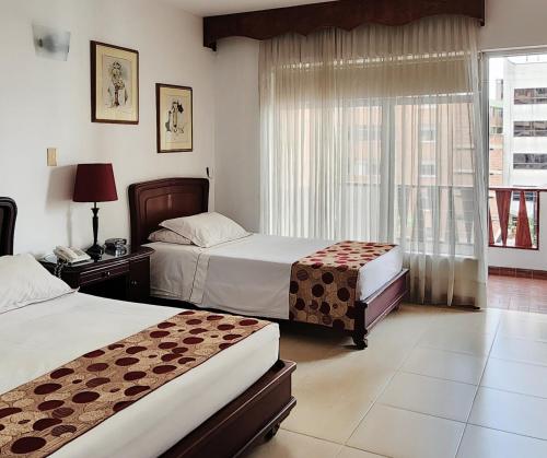 メデジンにあるGran Hotelのベッドが2つと窓があるホテルの部屋