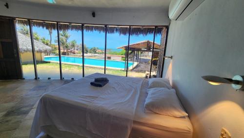 a bedroom with a bed and a view of a pool at Chácara Atlântica in Canoa Quebrada