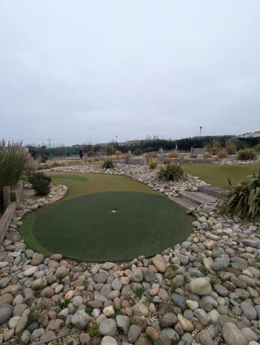 a golf course with a putting green and rocks at ACCESSIBLE FRIENDLY MODERN Family Caravan Littlesea Haven Weymouth in Weymouth