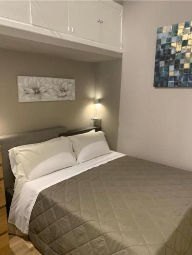 una camera da letto con un letto grande con cuscini bianchi di Sperlinga Suite a Palermo