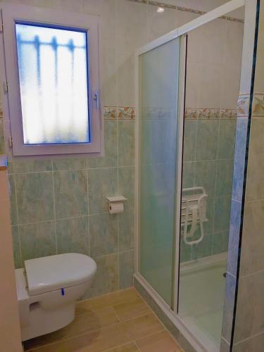 une salle de bain avec toilettes et douche en verre dans l'établissement Le Stud Thau, à Balaruc-les-Bains