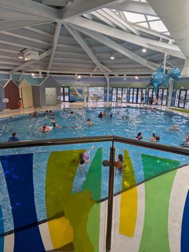 a group of people swimming in a swimming pool at Relaxing Holiday Home Chickerell View Littlesea Haven in Weymouth