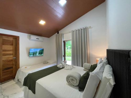a bedroom with two beds and a window at Pousada Monteflor Guaramiranga-CE in Guaramiranga