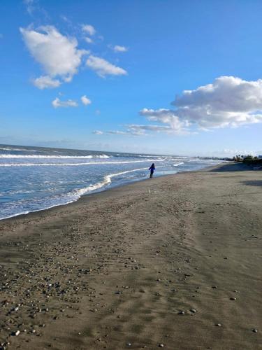 a person walking on a beach near the water at Casa Mayla in Manfredonia