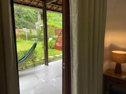 a sliding glass door with a hammock on a porch at Pousada Monteflor Guaramiranga-CE in Guaramiranga