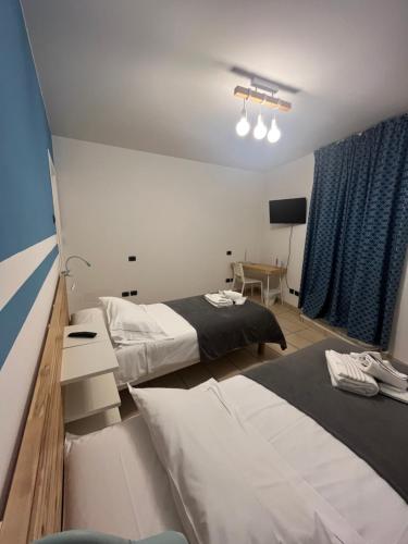 a hotel room with two beds and a desk at Dimora della Posta in Mondovì