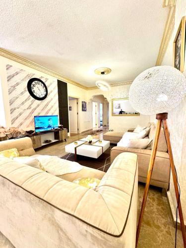 a living room with a couch and a clock on the wall at Stylish 3 Bedroom apartment in Amman in Amman