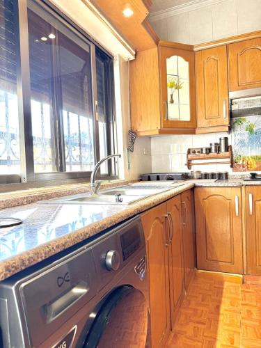 a kitchen with a washing machine in a sink at Stylish 3 Bedroom apartment in Amman in Amman