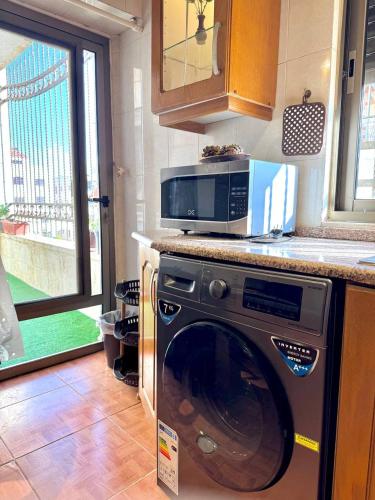 a kitchen with a microwave on top of a washing machine at Stylish 3 Bedroom apartment in Amman in Amman