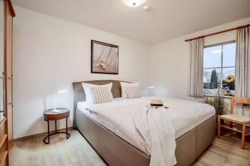 a bedroom with a large bed and a window at "Landhaus Voss" Typ 3 Nr9 in Staberdorf