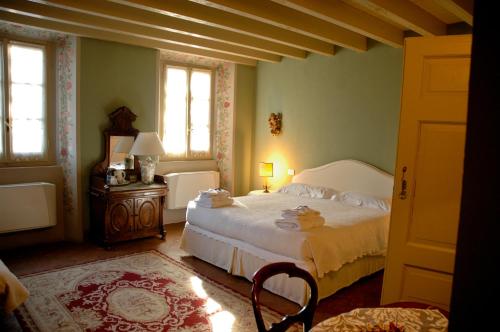 a bedroom with a white bed and two windows at Villa Valentina in Tradate