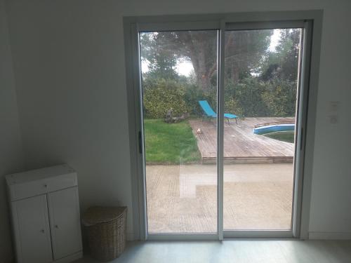 d'une porte coulissante en verre avec vue sur la piscine. dans l'établissement maison provence, à Mazan