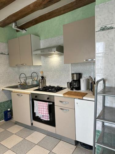 a kitchen with white cabinets and a stove top oven at Duplex de groupe - 5 chambres avec SDB in Villandry