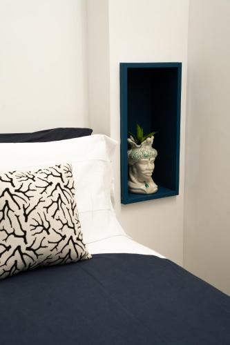 a vase sitting next to a bed with a pillow at 1912 Relais - Sorrento Coast in Piano di Sorrento