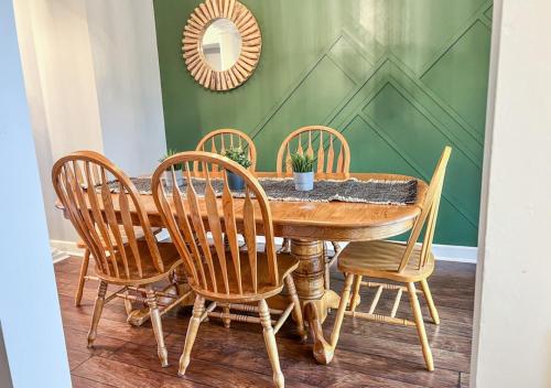 a dining room table with four chairs and a mirror at Relaxing Condo on the River - NEW Air Hockey Table in Pigeon Forge