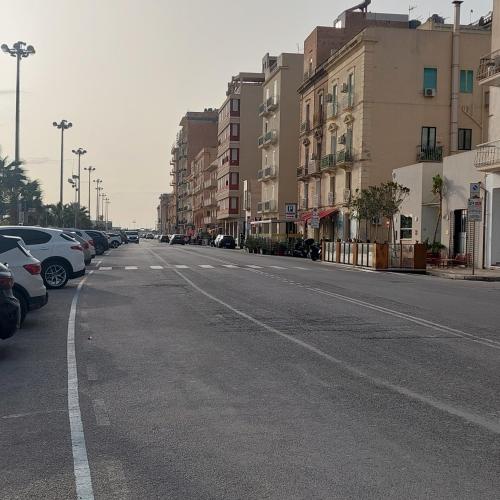 an empty city street with parked cars and buildings at MareAura in Trapani