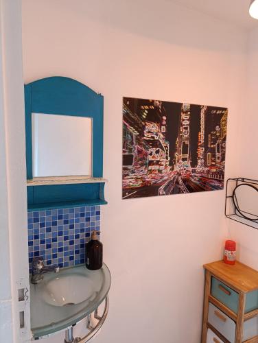 La salle de bains est pourvue d'un lavabo et d'une photo murale. dans l'établissement Appartement meublé avec parking tv box netflix, à Soyaux