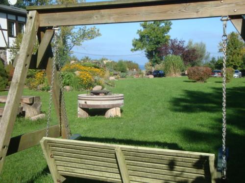 a park with a swing and a fountain in the grass at Gutspark Seeblick in Kägsdorf