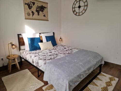a bedroom with a bed with blue pillows and a clock at Gîte la Basilique in Blois