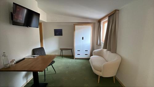 a room with a desk and a chair and a table at B&B das Alpinhotel Maistatt in Schladming