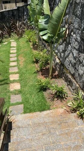a garden with a stone wall and some grass at Casa Indaiá in Petrópolis