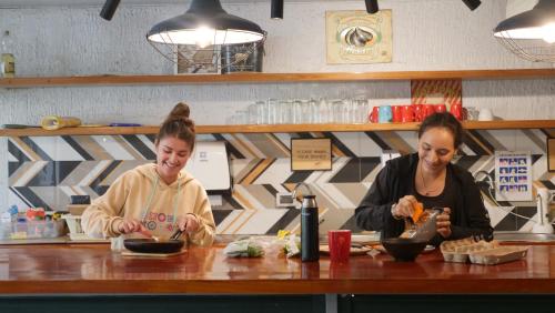 two women sitting at a counter preparing food at NAIA Miraflores Lima- Formerly Selina Miraflores Lima in Lima