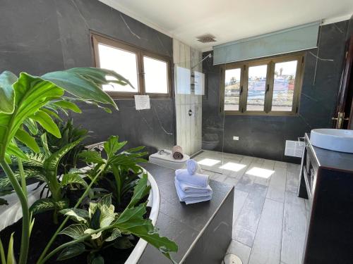 a bathroom with a tub and a sink and some plants at Finca Marisa in Tinajo