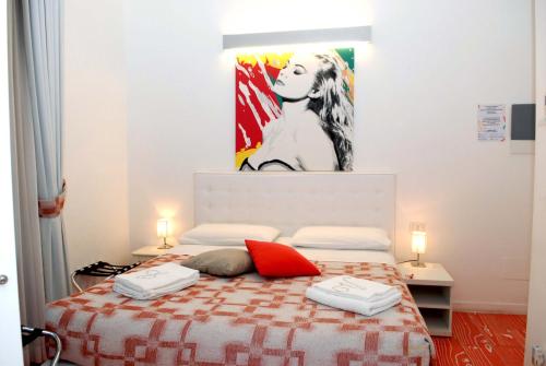 a bedroom with a bed with a painting on the wall at Divine Bed & Breakfast in Rome