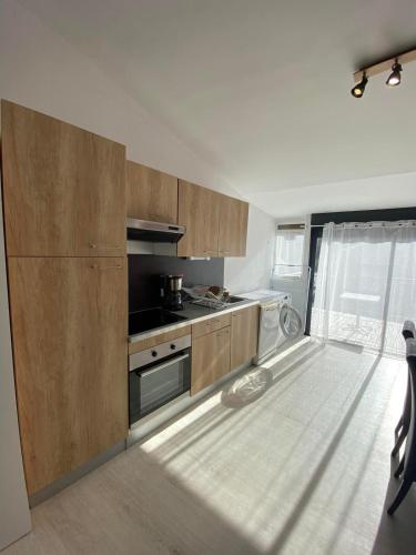 - une cuisine avec des placards en bois et une cuisinière dans l'établissement Gîte 3 chambres à Villandry, à Villandry