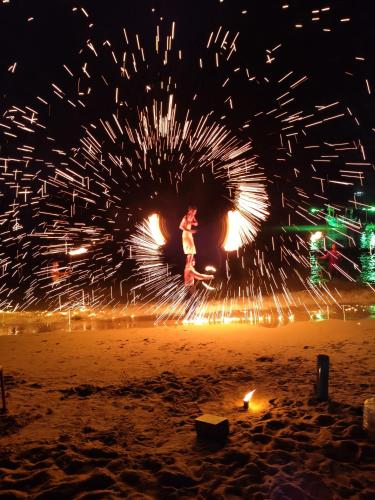 a person jumping in the air with fireworks at night at Yuyu Golden Beach in Ko Chang