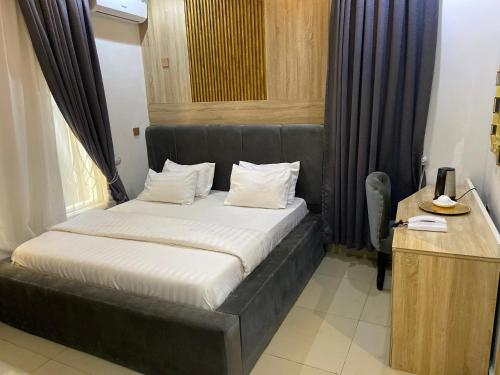 une chambre avec un lit avec une tête de lit noire dans l'établissement Domar Suites, à Ozuoba