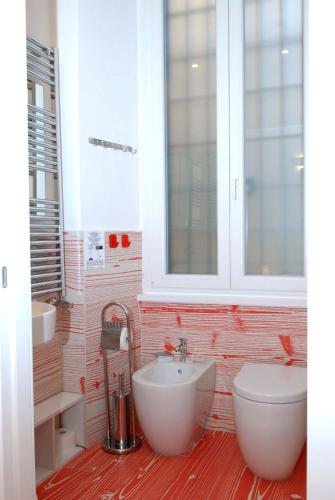 a bathroom with a sink and a toilet and a window at Divine Bed & Breakfast in Rome