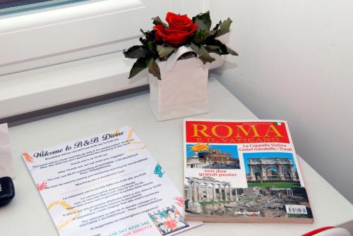 a table with a book and a vase with a red rose at Divine Bed & Breakfast in Rome