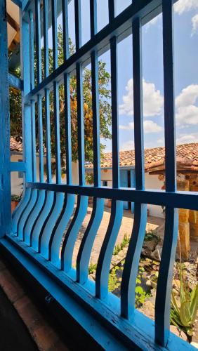 a blue fence with a view of a house at Casa Raisol Barichara in Barichara