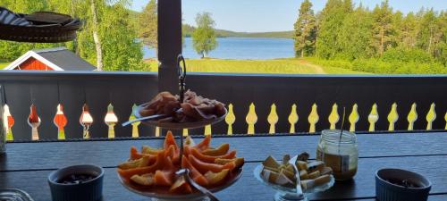 a table with plates of food and a view of a lake at Wild Power Guesthouse in Lycksele