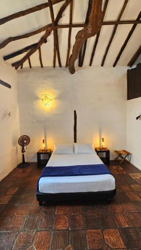 a bedroom with a bed in a room with a ceiling at Casa Raisol Barichara in Barichara