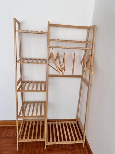 a wooden shelf with hangers and shoes on it at La Maison Samaï in Urubamba