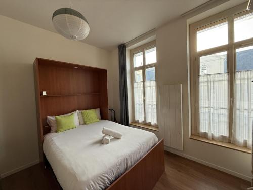 une chambre avec un grand lit et deux fenêtres dans l'établissement Le Chanzy - Centre - 7 pers - Reve au Mans, au Mans